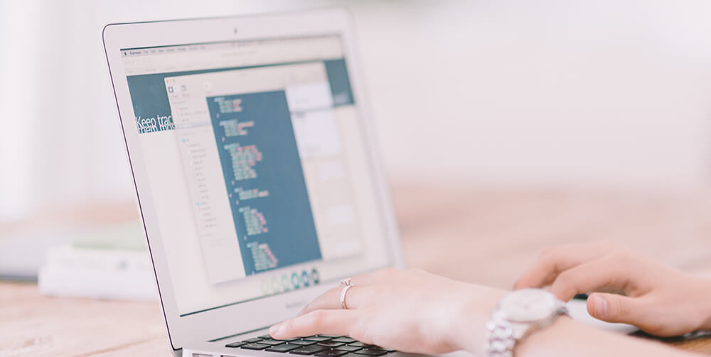 A web developer typing on a laptop