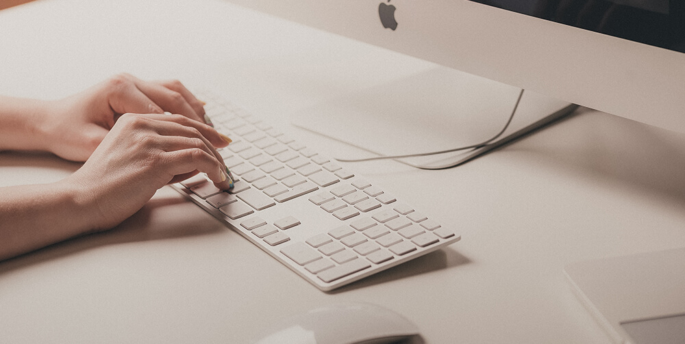 Person typing on a mac keyboard