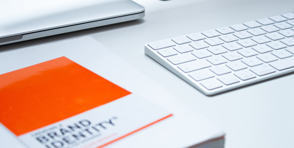 A brand identity book next to a keyboard